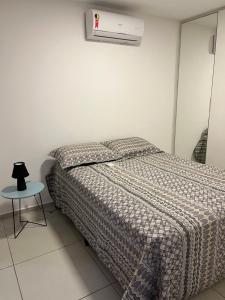 1 dormitorio con cama y mesa pequeña en Maravilhoso apartamento em João Pessoa, en João Pessoa