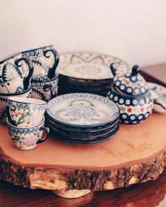 un gruppo di piatti e tazze su un tavolo di legno di Lipolas-slowlife&guesthouse a Jurków