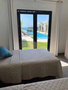 1 dormitorio con cama y vistas a la piscina en Riviera Vichayito, en Vichayito