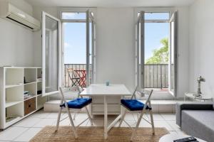 salon z białym stołem i krzesłami w obiekcie Appartement Chaudron - Welkeys w Marsylii