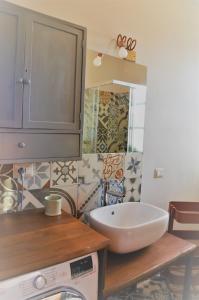 a bathroom with a sink and a washing machine at Cascina Villa - Casa di campagna tra le nocciole in Levice