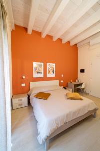 2 Betten in einem Schlafzimmer mit orangefarbener Wand in der Unterkunft The Garden in Canistro