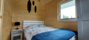 a bedroom with a bed in a wooden cabin at Domki Pod Sudeckim Niebem in Duszniki Zdrój
