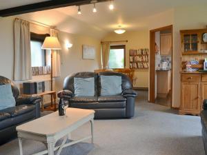 Moorview Cottage في Marytavy: غرفة معيشة مع كرسيين جلديين وطاولة قهوة