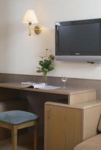 Zimmer mit einem Schreibtisch und einem TV an der Wand in der Unterkunft Hotel the Wigwam in Domburg