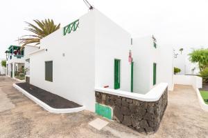 un edificio bianco con accenti verdi sul lato di Casa Martín a Puerto del Carmen