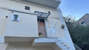 ein weißes Gebäude mit einer Treppe und einem Balkon in der Unterkunft Parva Domus in Matera