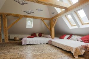 two beds in a attic room with windows at Vilegiatura/Florica Socolescu Villa in Sinaia