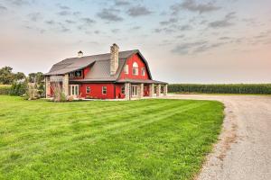 a red barn on a field with a dirt road at Charming Jeffersonville Barndominium with Fire Pit! in Jeffersonville