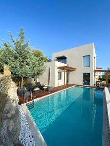 a swimming pool in front of a house at Dimeli - Sea View Villas in Foinikounta in Finikounta