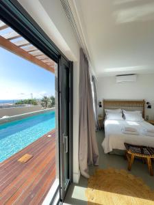 a bedroom with a bed and a swimming pool at Dimeli - Sea View Villas in Foinikounta in Finikounta