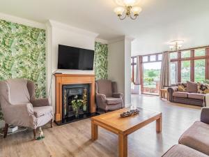 a living room with a fireplace and a tv at Riversdelle in Beccles