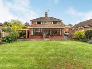 a large house with a grass yard in front of it at Riversdelle in Beccles