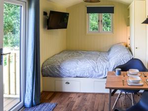 een kleine slaapkamer met een bed en een tafel bij Beech - Ukc4847 in Cantley