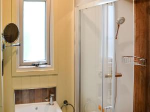 een badkamer met een douche, een wastafel en een raam bij Beech - Ukc4847 in Cantley