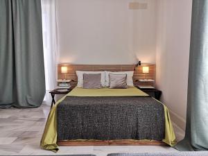 - une chambre avec un grand lit et 2 tables de chevet dans l'établissement White Loft Alameda, à Séville