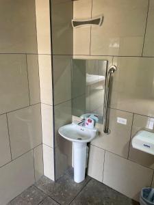 a bathroom with a white sink and a shower at Hotel Wilson Santa Cruz in Santa Cruz