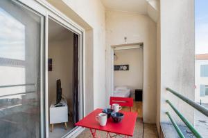 a red table with bowls on it on a balcony at Appartement Vanneau - Welkeys in Dolus d'Oléron