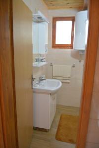 uma casa de banho com um lavatório branco e uma janela em Dobar pogled em Bajina Bašta