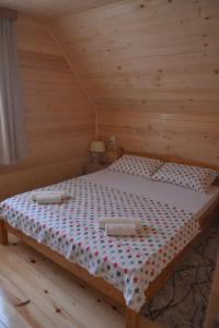 uma cama num quarto de madeira com duas toalhas em Dobar pogled em Bajina Bašta
