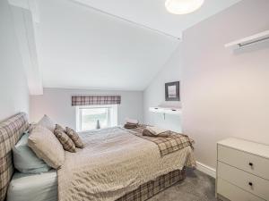 a white bedroom with a bed and a window at Emmaville in Ryton