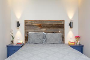 a bedroom with a bed with blue nightstands and a wooden headboard at Cozy Collingwood Retreat 80204 in Collingwood