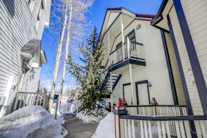 a white house with a fence in the snow at Brittany Place Condo - Great Downtown Location - On Main St in Breckenridge