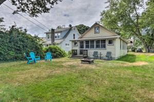 舊賽布魯克的住宿－Grandmas Cottage with Sunroom Walk to Beach，院子里有两把蓝色椅子的房子