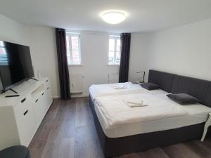 a bedroom with a bed and a flat screen tv at ARGENTA Living - QUELLQUARTIER in Fulda