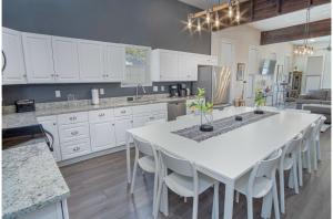 a white kitchen with a large white table and chairs at Gorgeous Family-Friendly Home Near Downtown in San Antonio