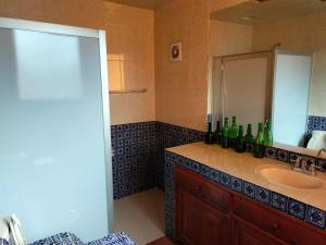 un baño con lavabo con botellas de vino. en Cabañas y habitaciones Los Cedros, en Zacatlán