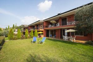 a house with two chairs and a yard at Appartamenti Gianni in Torri del Benaco