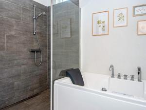 een badkamer met een douche, een bad en een toilet bij 7 person holiday home in Hejls-By Traum in Hejls +24 foto's