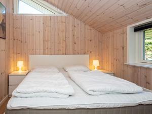 een slaapkamer met twee witte bedden in een houten muur bij 7 person holiday home in Hejls-By Traum in Hejls