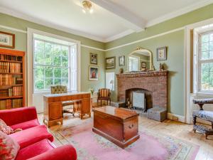 a living room with a fireplace and a red couch at Hodroyd Hall in Holmfirth