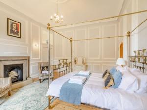 a bedroom with a four poster bed and a fireplace at Hodroyd Hall in Holmfirth