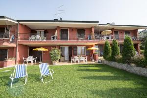 two chairs and umbrellas on a lawn in front of a building at Appartamenti Gianni in Torri del Benaco +41 photos