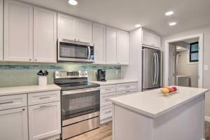 una cocina con armarios blancos y electrodomésticos de acero inoxidable en Fully Renovated Ocean Front Condo at Sea Colony, en Bethany Beach