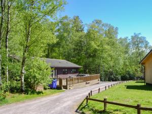 una casa en un camino al lado de una valla en Leafy Run, en Otterburn