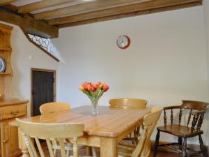 a wooden table with chairs and a vase of flowers on it at Stable Cottage - Ukc3630 in Adlestrop