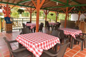 un restaurante con mesas y sillas con mesas a cuadros rojas y blancas en Finca Hotel Villa Mariana, en Montenegro