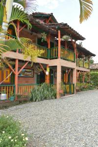 a wooden house with a balcony and a palm tree at Finca Hotel Villa Mariana in Montenegro