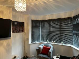 a living room with a chair and a window at Stylish and homey 3 bedroom house with free parking & Wi-Fi in Minworth