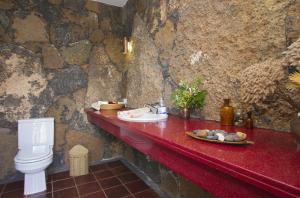 a bathroom with a red counter with a toilet at Villa Remedios in Teguise