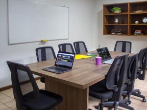 a conference room with two laptops on a wooden table at BauHouse Asuncion in Asunción
