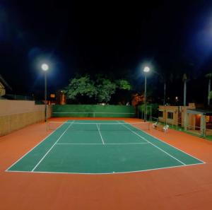 una pista de tenis por la noche con dos luces en BauHouse Asuncion, en Asunción