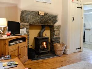 a fireplace in a living room with a stove at Bryn Ysgol in Yspytty-Ifan