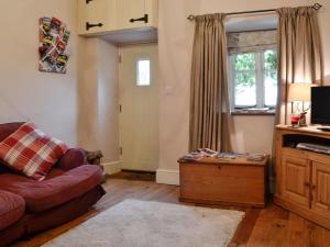 a living room with a couch and a window at Bryn Ysgol in Yspytty-Ifan