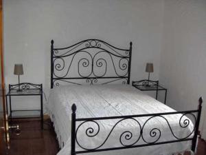 a bedroom with a black and white bed with two tables at Casa da Janal in Vimioso