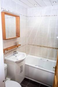 a bathroom with a sink and a toilet and a tub at Charming 1-bed Southside Flat in Great Location in Kings Park